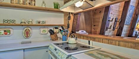 Una cocina con armarios de madera, una estufa y diferentes utensilios.