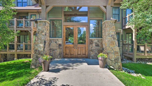 A two-story building with a stone facade, a wooden front door, and a covered porch with railings. - 5 Mi to Ski Resort: Breck Penthouse Studio (Breckenridge)