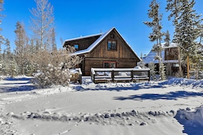 A wooden cabin with a snow-covered roof, surrounded by snow and trees. - Spacious Grand Lake Cabin w/ Hot Tub & Deck (Grand Lake)
