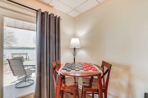 A corner room with a wooden table and chairs, a lamp, and a view of the outdoors. - Watts Bar Lake Escape: Private Boat Dock + Ramp! (Spring City)