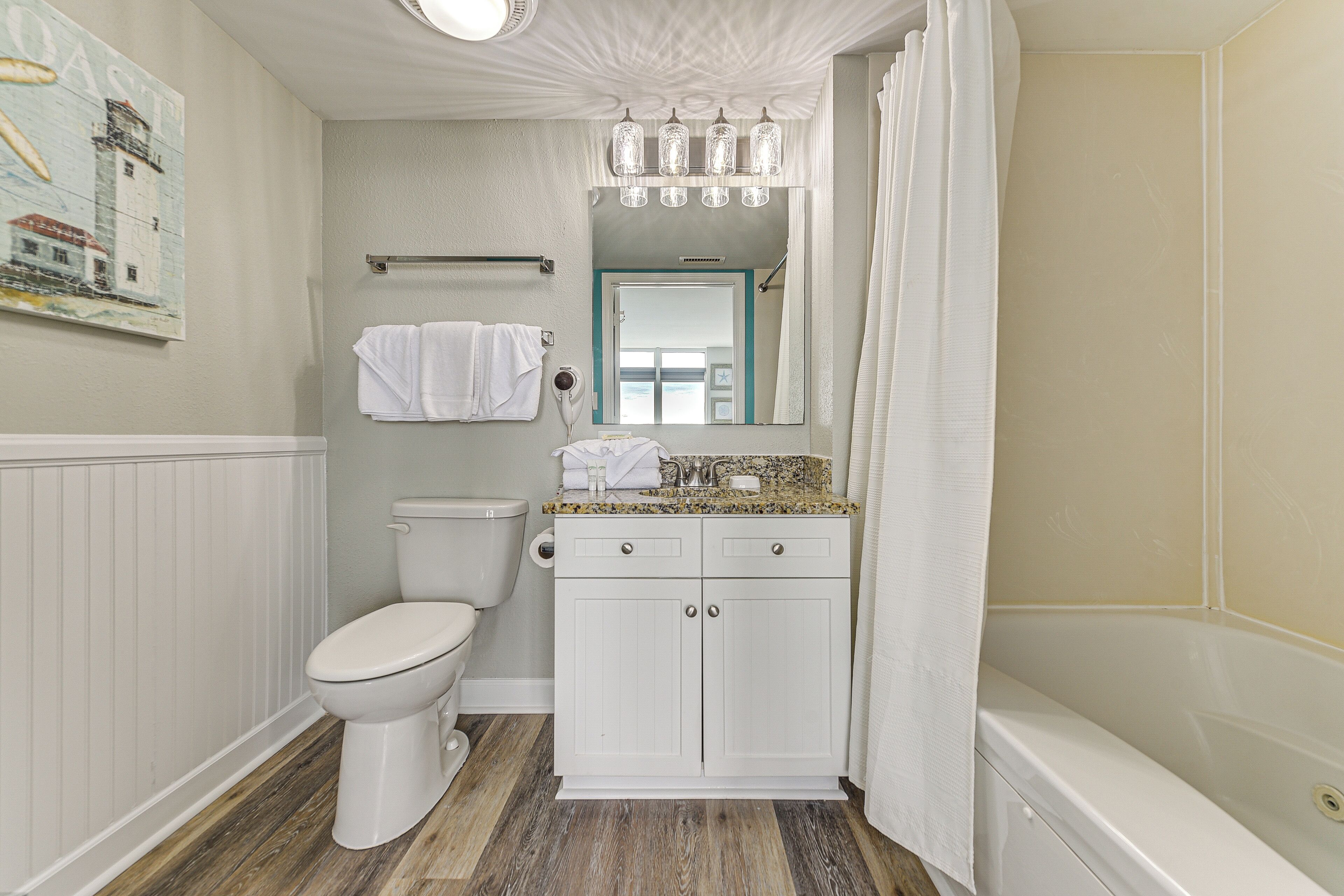A bathroom with a toilet, sink, and shower.