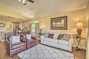 A living room with a sofa, two armchairs, a rug, a lamp, and a painting on the wall. - 1 Block to Branson Strip: Condo w/ Views & Pool! (Branson)