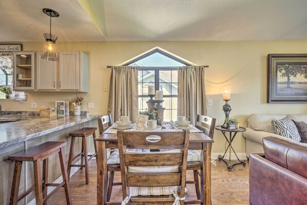 A dining area with a wooden table, chairs, and a kitchen counter. - 1 Block to Branson Strip: Condo w/ Views & Pool! (Branson)