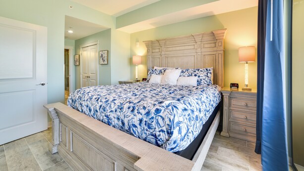 A bedroom with a bed, nightstands, a dresser, and a ceiling fan. - Breezy Panama City Beach Condo w/ Private Balcony! (Panama City Beach)