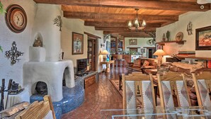 A rustic interior with exposed wooden beams, a stone fireplace, and traditional decor. - Riverheart Retreat - One-of-a-kind Villa! (Buena Vista)