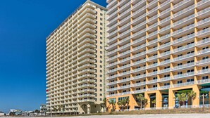 Un hotel de gran altura con múltiples balcones y vista al mar.
