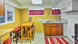 A compact kitchen with a wooden table and stools, a microwave, and a sink. - Lakefront Retreat w/ Dock, Paddle Boards & Kayaks! (Clearlake)