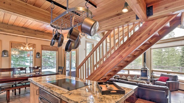 Una cocina amplia con una isla grande, vigas de madera y vistas al exterior.
