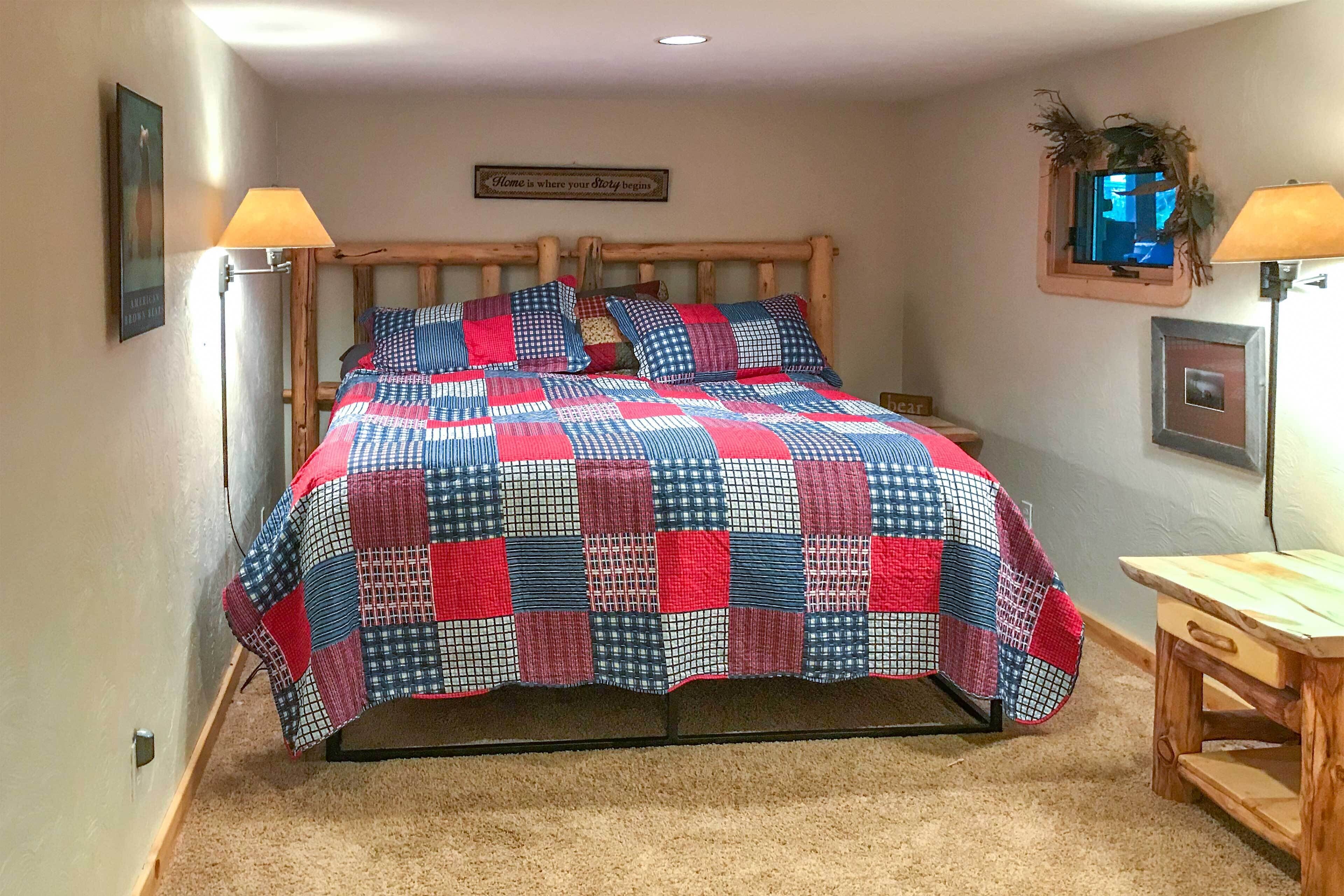 Une chambre à coucher avec un cadre de lit en bois, une couvre-lit matelassé, une table de chevet, une lampe et une citation encadrée accrochée au mur.