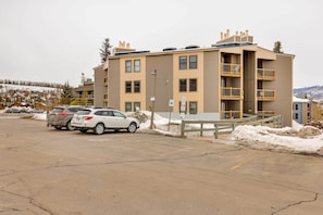 A multi-story building with a parking lot in front. - Silverthorne Condo W/pool Access - Shuttle to Town (Silverthorne)