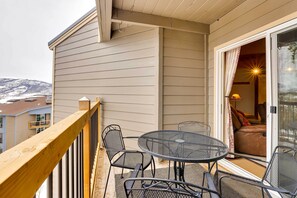 A balcony with a table and chairs, a sliding glass door, and a view of a snowy landscape. - Silverthorne Condo W/pool Access - Shuttle to Town (Silverthorne)