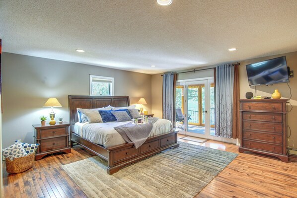 A bedroom with a bed, nightstands, a dresser, a television, and a view of the outdoors. - Casa Immaculata on Chalk Creek w/ Views! (Nathrop)