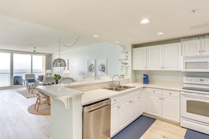 A modern kitchen with white cabinets, a dishwasher, and a built-in oven.