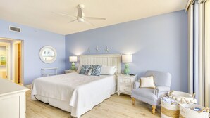 Une chambre à coucher avec un lit, des tables de chevet, une chaise et une fenêtre.
