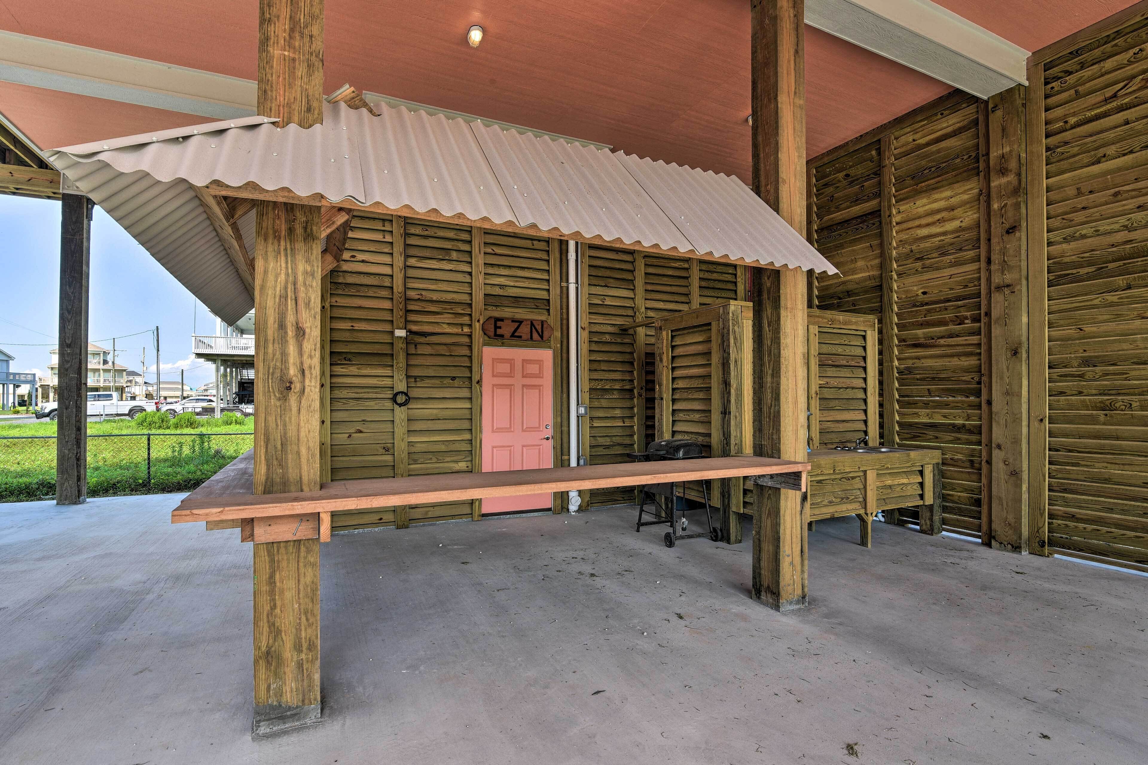 A rustic wooden building with a corrugated metal roof, a bench, and a pink door labeled "EZN".