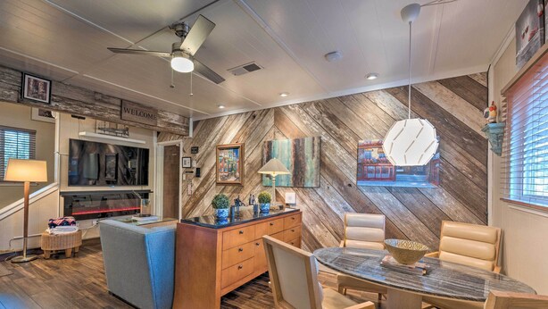 A modern kitchen with a wooden herringbone wall, a built-in oven, and a dining area with a round table and chairs. - Luxurious Downtown Lodi Apartment in Wine Country! (Lodi)