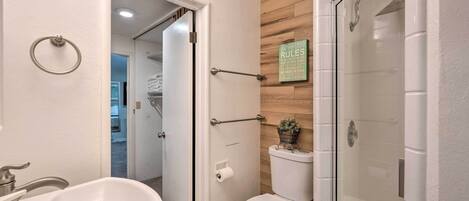 A bathroom with a bathtub, toilet, and glass-enclosed shower.