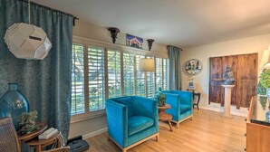 A living room with two blue armchairs, a wooden coffee table, and a large window with blinds. - Spacious Wine Country Home: 1 Mi to Downtown Lodi! (Lodi)