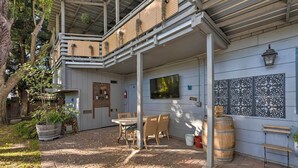 A covered patio area with a table and chairs, a wooden barrel, and decorative wall panels. - Spacious Wine Country Home: 1 Mi to Downtown Lodi! (Lodi)