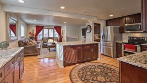 A spacious kitchen with wooden cabinets, stainless steel appliances, and a central island. - Private Yard + Patio: Denver Area Home! (Northglenn)