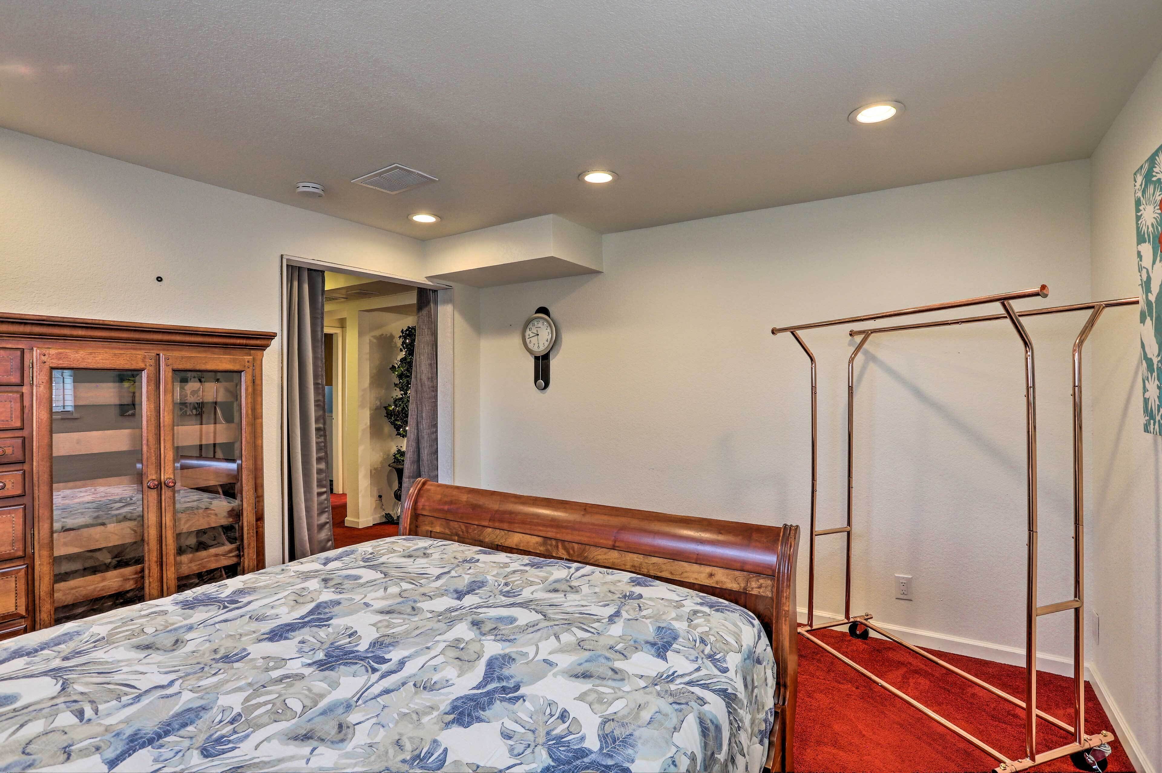 A bedroom with a bed, wooden wardrobe, and a metal wardrobe unit.