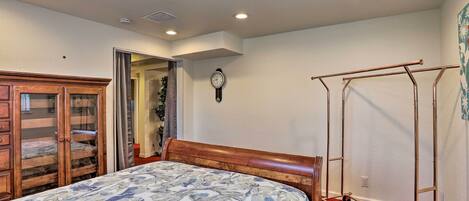 A bedroom with a bed, wooden wardrobe, and a metal wardrobe unit.