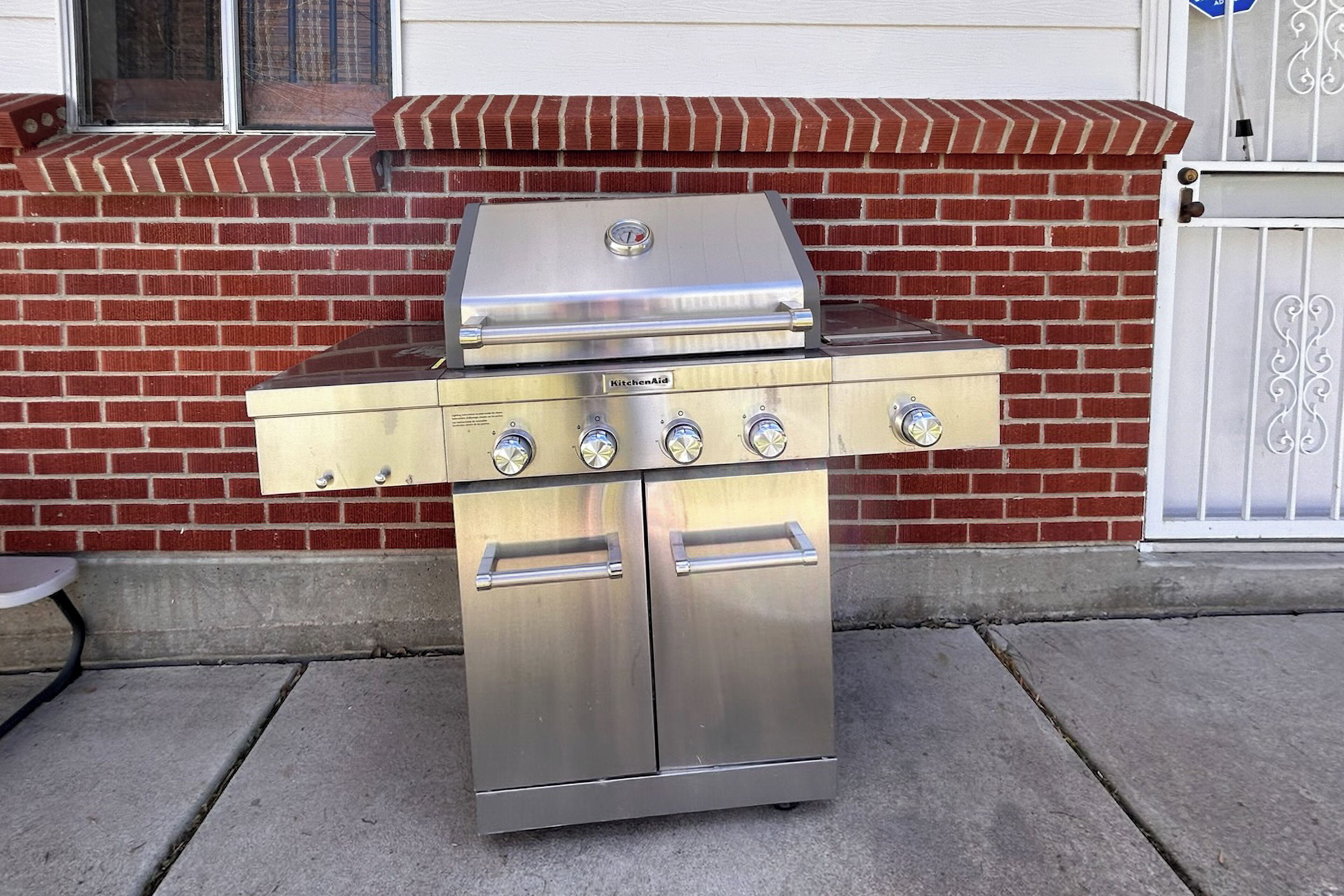 A stainless steel outdoor kitchen with a grill, four burners, and a sink.