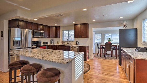 A modern kitchen with granite countertops, stainless steel appliances, and wooden cabinets. - Private Yard + Patio: Denver Area Home! (Northglenn)