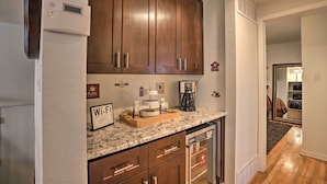 A kitchen with wooden cabinets, a built-in microwave, a coffee maker, and a Wi-Fi sign. - Private Yard + Patio: Denver Area Home! (Northglenn)