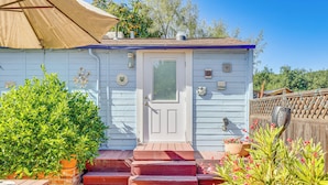 A small, single-story house with a white door, a small porch with steps, and a wooden fence in the background. - Romantic Casita w/ Garden + Deck 2 Miles to Plaza! (Sonoma)