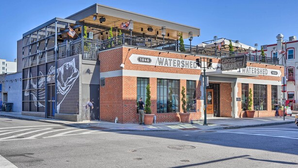 A two-story building with a sign reading "WATERSHED" and "1846" on the facade. - Baltimore Abode, Walk to Cross Street Market! (Baltimore)