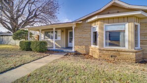 A single-story house with a front porch, a covered entryway, and a visible garage door. - Tulsa Home w/ Yard: 5 Mi to Downtown! (Tulsa)