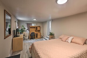 A bedroom with a bed, a desk, and a chair.