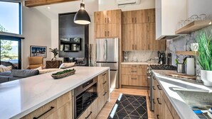A modern kitchen with wooden cabinets, stainless steel appliances, and a large island.