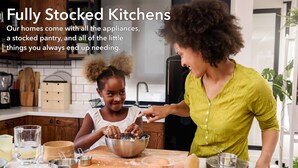 A kitchen with a fully stocked pantry, various appliances, and a woman and child baking together. - Cottonwoods 419 (Moab)