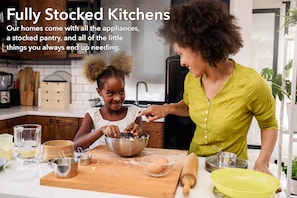 Een koelkast met diepvriezer, een microgolfoven, een oven, een kookplaat