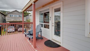 A covered porch with two Adirondack chairs, a wooden deck, and a view of neighboring houses. - Oceanview Rockaway Beach Condo w/ Deck & Gas Grill (Rockaway Beach)