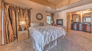 Un dormitorio con una cama grande, un aparador, un espejo y una ventana.