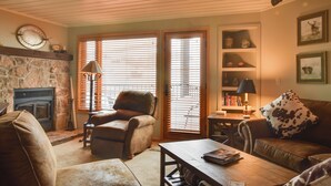 A cozy living room with a fireplace, leather furniture, and a bookshelf. - 'eagle's Nest' Crested Butte Townhome w/ Mtn Views (Crested Butte)
