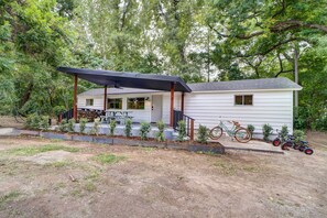 A single-story house with a covered porch, a small front yard, and a bicycle parked outside. - Scenic Tulsa Getaway w/ Deck + Fire Pit (Tulsa)