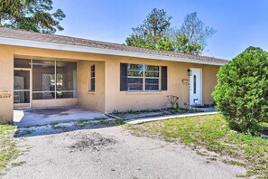 A single-story house with a front porch, a garage, and a small front yard. - Sun-soaked Bradenton Home w/ Screened Porch! (Bradenton)