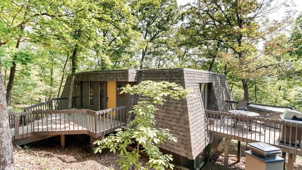 A treehouse with a wooden deck and a small outdoor kitchen area. - Families w/ Pets! Lake-view Osage Beach Home (Osage Beach)