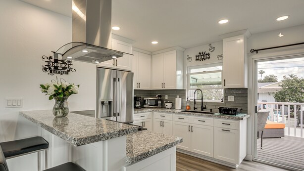 A modern kitchen with white cabinets, granite countertops, and stainless steel appliances. - 'breeze by the Marina' Chula Vista Getaway! (Chula Vista)