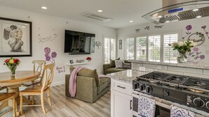 A modern kitchen with a gas stove, wooden dining table, and chairs. - 'breeze by the Marina' Chula Vista Getaway! (Chula Vista)