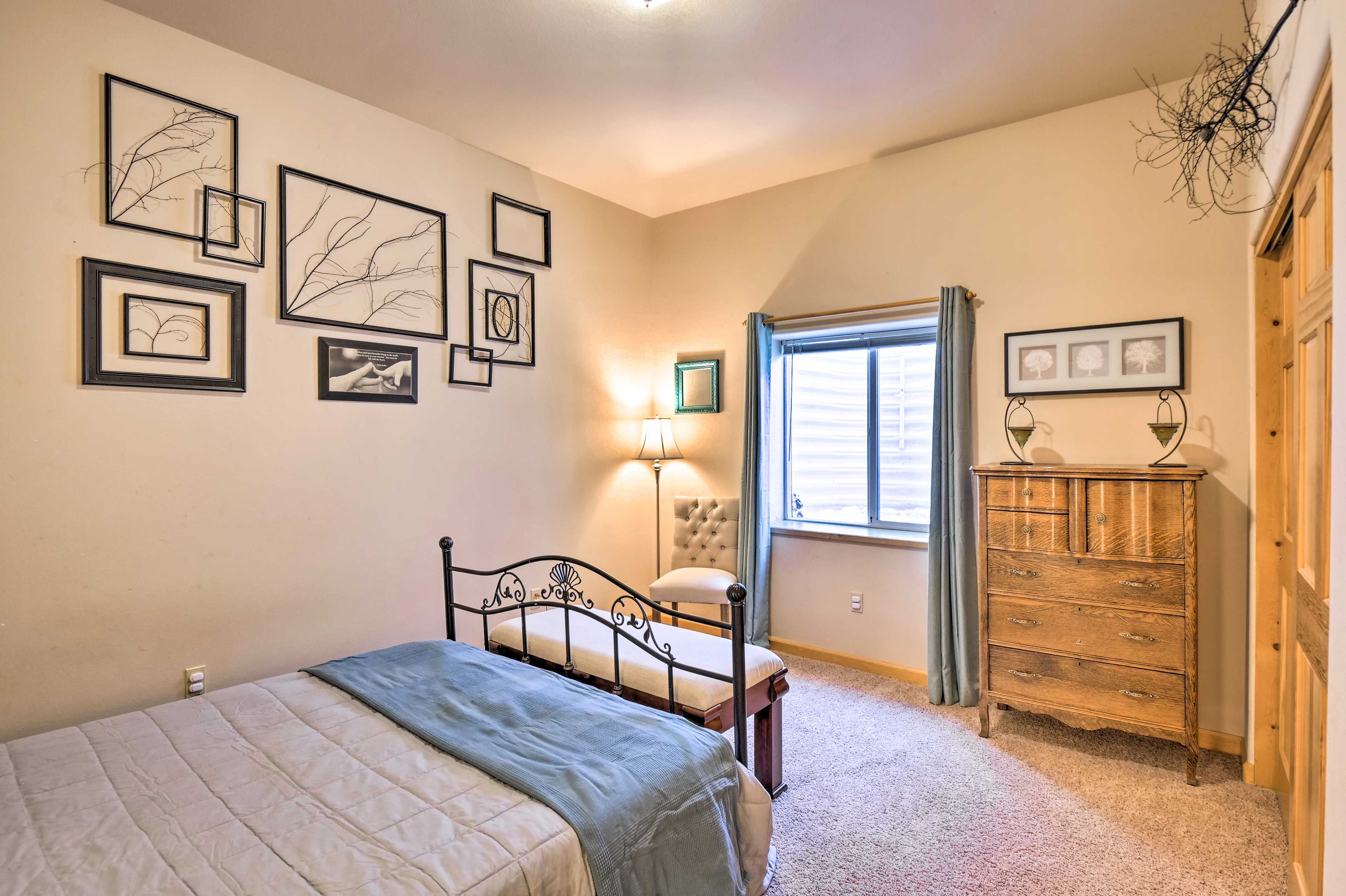 Ein Schlafzimmer mit Bett, Kommode und Wandbildern.