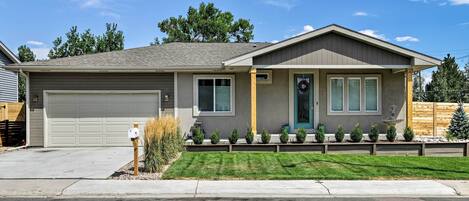 A single-story house with a garage, a front porch with a small fountain, and a well-maintained lawn.