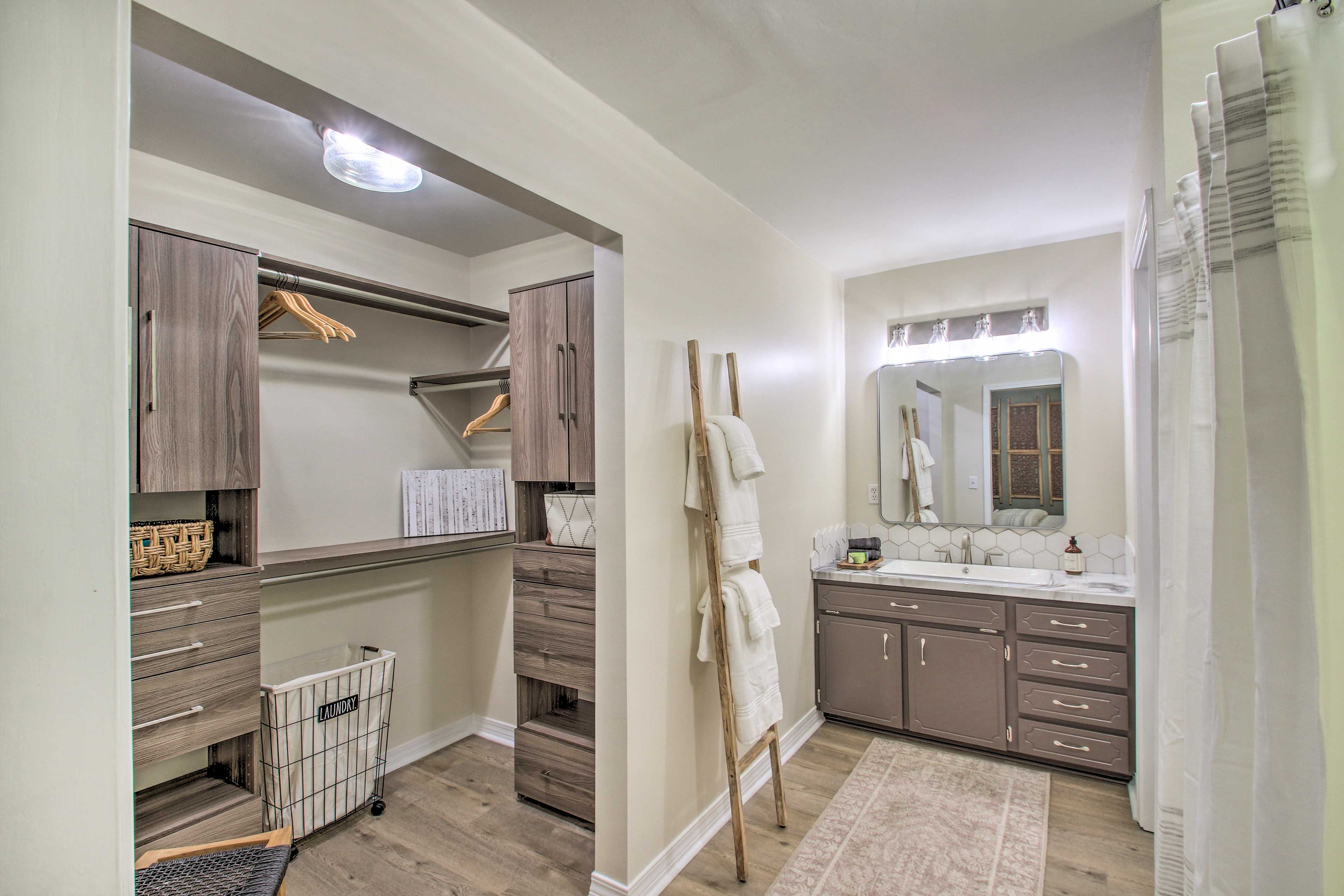 A modern bathroom with a vanity, mirror, and built-in storage.