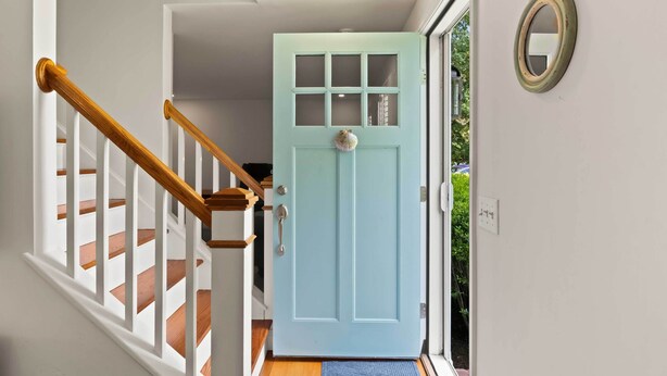 A staircase with wooden handrails and a light blue door with glass panels. - 3 Bicycles Provided! Cape Cod Cottage w/ Deck (Orleans)