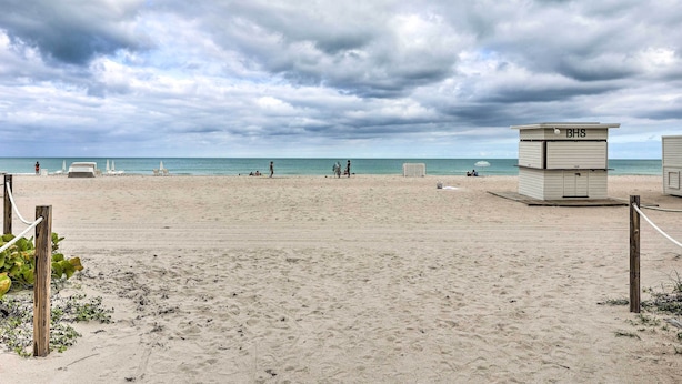A beach with a lifeguard tower labeled "BH8" and a sandy beach area. - Sunny Miami Beach Condo Steps to Boardwalk! (Miami Beach)