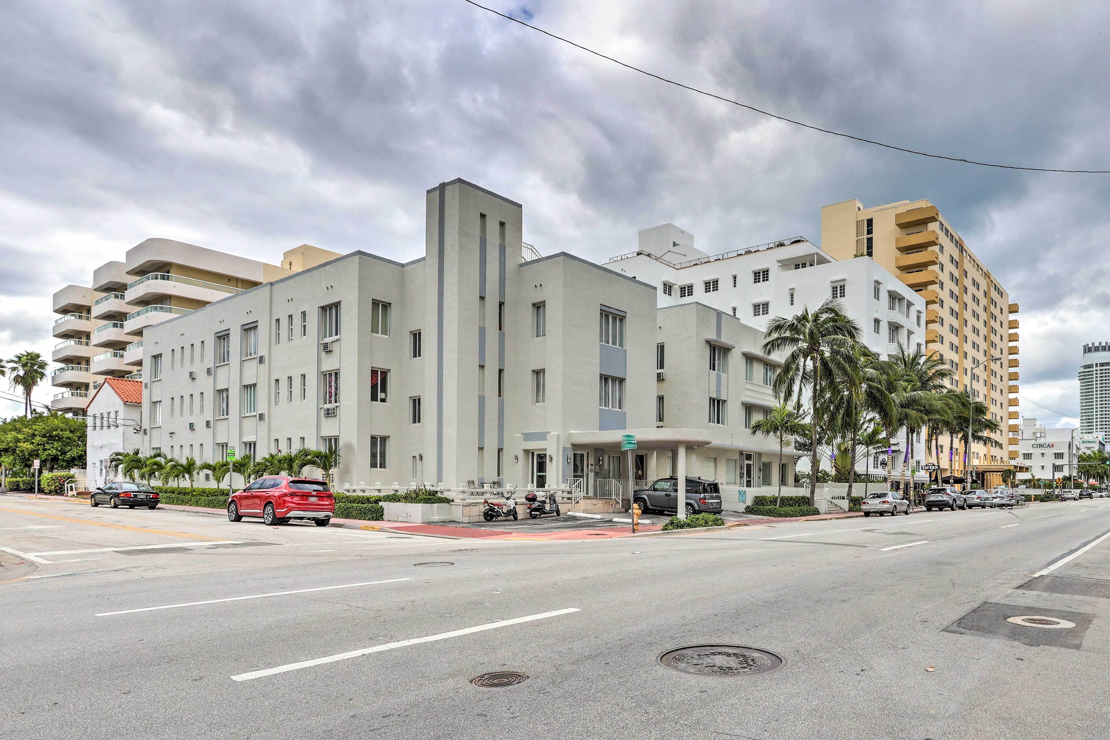 A multi-story hotel with a modern architectural design, featuring balconies and a central entrance.